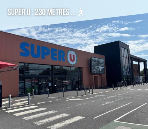 a super store in a parking lot at Les continents maison spacieuse 4 belles chambres parking privatif terrasse à 5 mn à pied tous commerces et 20 mn plage Omaha Beach et à 15 mn de Bayeux in Le Molay-Littry