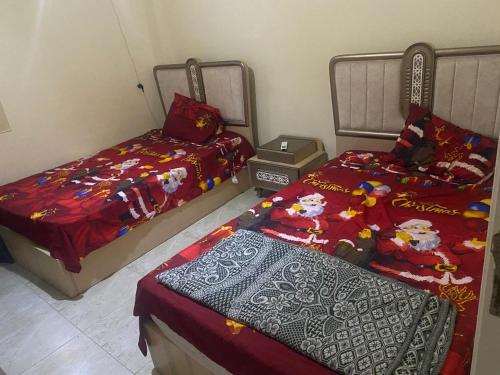 a bedroom with two beds and a laptop in it at استيلا هايتس الساحل الشمالي in Dawwār ‘Abd al Qādir Qāsim