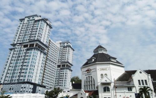 a group of tall buildings and a building with a clock tower at Vasaka The Reiz Condo in Medan