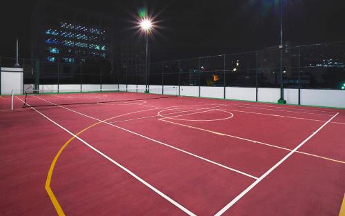 a tennis court is lit up at night at Vasaka The Reiz Condo in Medan