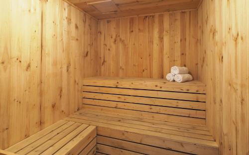 a wooden sauna with two towels sitting on a shelf at Vasaka The Reiz Condo in Medan