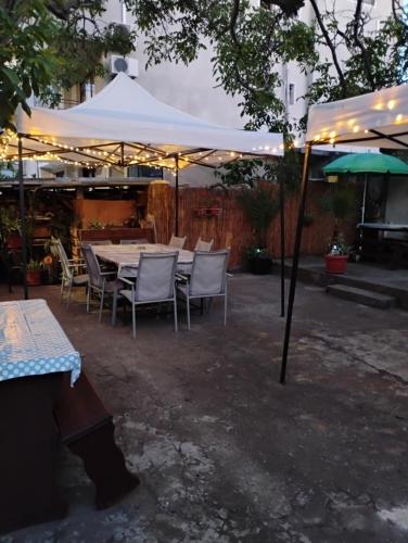a table and chairs under a white umbrella at Вила Радеви in Obzor