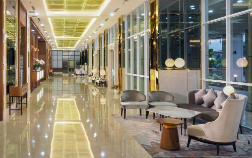 a lobby with chairs and tables in a building at Vasaka The Reiz Condo in Medan