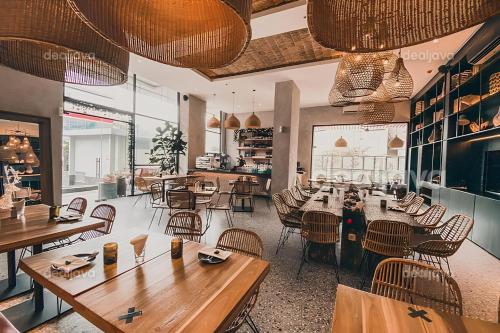 a restaurant with tables and chairs in a room at Vasaka The Reiz Condo in Medan