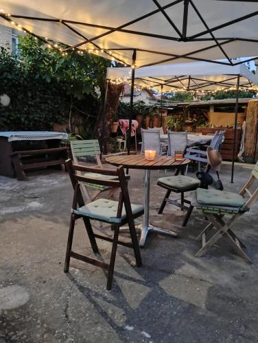a wooden table and chairs under an umbrella at Вила Радеви in Obzor