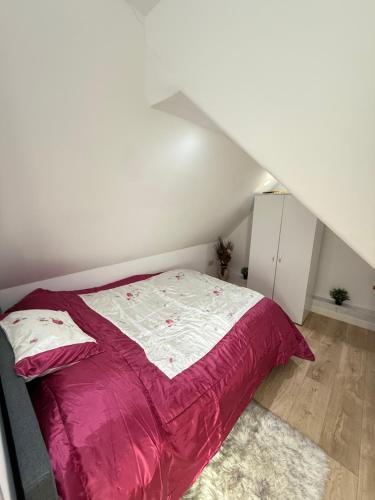 a bed with a pink comforter in a room at A Lovely and Cosy Studio Apartment in Navestock