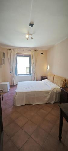 a bedroom with a large white bed and a window at Palazzo Cafarelli in Laureana Cilento