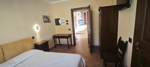 a bedroom with a bed and a table and a door at Palazzo Cafarelli in Laureana Cilento