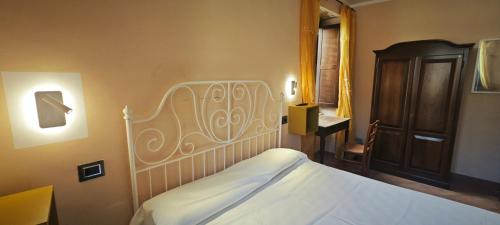 a bedroom with a white bed and a wooden cabinet at Palazzo Cafarelli in Laureana Cilento