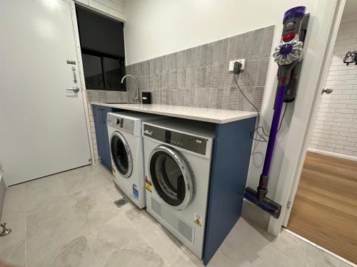 a laundry room with a washer and dryer at Central Cullen Wagga Apartments in Wagga Wagga