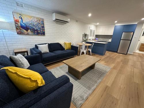 a living room with a blue couch and a table at Central Cullen Wagga Apartments in Wagga Wagga