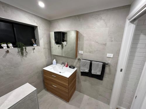 a bathroom with a sink and a mirror at Central Cullen Wagga Apartments in Wagga Wagga