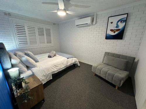 a bedroom with a bed and a couch in it at Central Cullen Wagga Apartments in Wagga Wagga
