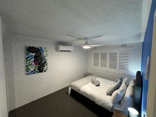 a room with a couch and a ceiling fan at Central Cullen Wagga Apartments in Wagga Wagga