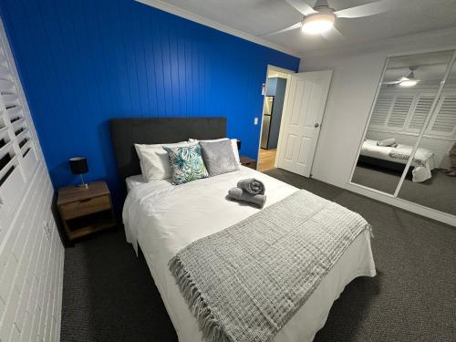 a bedroom with a large bed with a blue wall at Central Cullen Wagga Apartments in Wagga Wagga