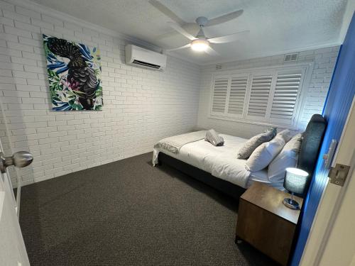 a bedroom with a bed and a couch in it at Central Cullen Wagga Apartments in Wagga Wagga
