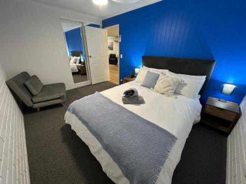 a bedroom with a large bed with a blue wall at Central Cullen Wagga Apartments in Wagga Wagga
