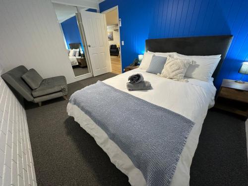 a bedroom with a large bed and a chair at Central Cullen Wagga Apartments in Wagga Wagga