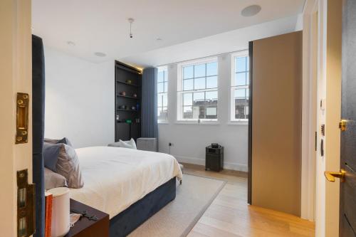 a bedroom with a bed and a window at Mayfair Residences in London