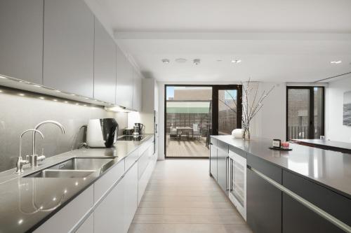 a kitchen with white cabinets and a large counter top at Mayfair Residences in London