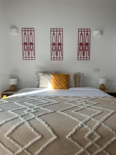 a bedroom with a bed and two artworks on the wall at Solar de Arrayollos by PURUS in Arraiolos