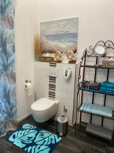 a bathroom with a toilet and a shelf with towels at Moderne Ferienwohnung Nähe Bad Griesbach, Haarbach in Haarbach