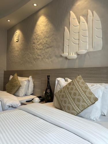 two beds in a hotel room with white sheets and pillows at Vastu Boutique Hotel in Kathmandu