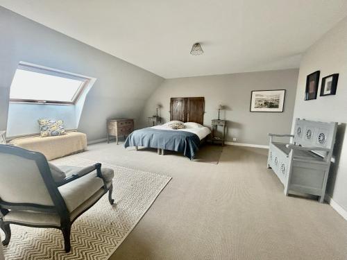 une chambre avec un lit, une chaise et une fenêtre dans l'établissement Ty Traez, holiday house for families in Cap Sizun, à Primelin