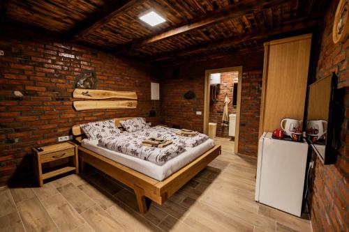 ein Schlafzimmer mit einem großen Bett in einer Ziegelwand in der Unterkunft Etno Camp Lucić in Odžak