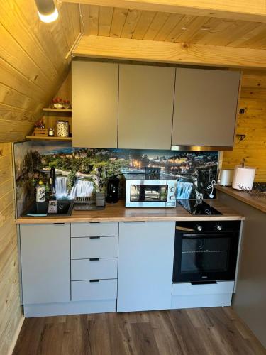 a kitchen with white cabinets and a stove at Cottage MIRNI RAJ in Jajce