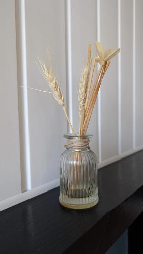 a glass vase with dried grasses in it on a table at Apartment Wexford Crescent Mall in Wexford