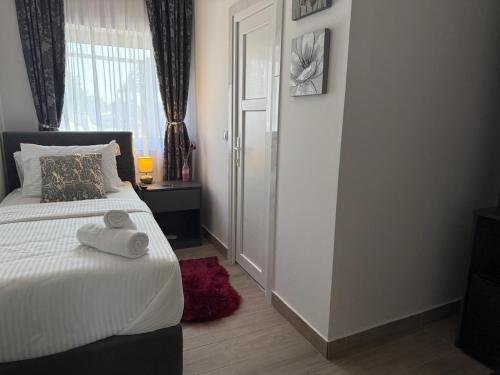 a bedroom with a bed and a window and a door at Alsago Lux in Sesvete