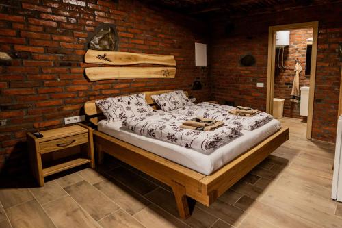 a bed in a room with a brick wall at Etno Camp Lucić in Odžak
