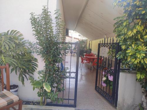 an open gate with plants on the side of a building at Galia Apartment in Ksamil