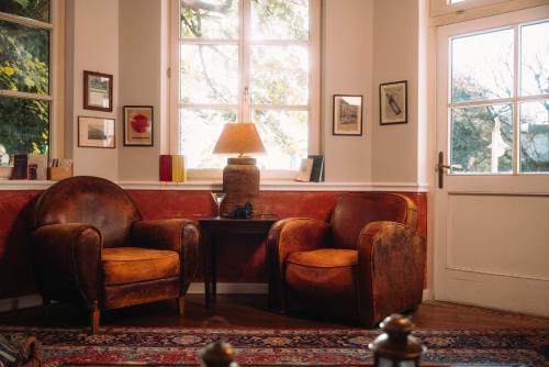 a waiting room with two chairs and a table and windows at Cortisen am See - Adults only in St. Wolfgang
