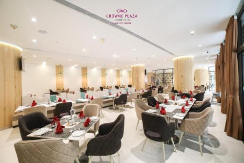 a restaurant with tables and chairs in a room at Crowne Plaza Pune City Centre by IHG in Pune