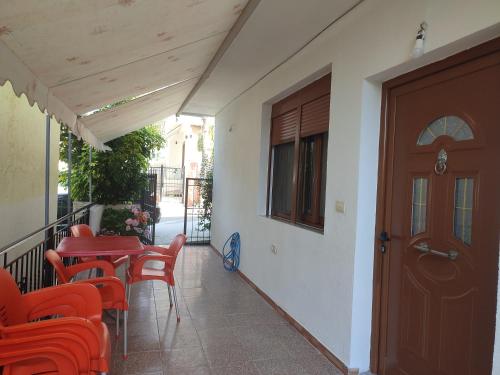 a balcony with a table and chairs and a door at Galia Apartment in Ksamil