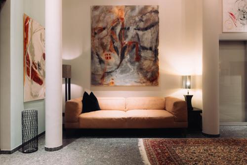 a living room with a couch and a painting on the wall at Cortisen am See - Adults only in St. Wolfgang