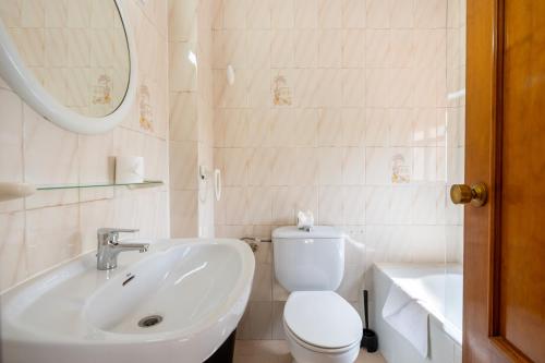 a white bathroom with a toilet and a sink at BF Rooms Garrucha in Garrucha