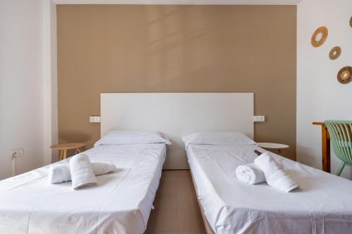 two beds in a room with white sheets and pillows at BF Rooms Garrucha in Garrucha