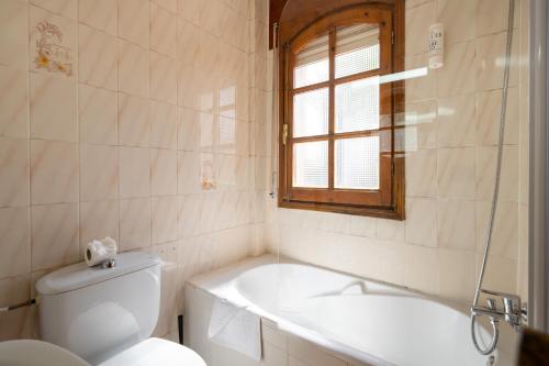 a bathroom with a tub and a toilet and a sink at BF Rooms Garrucha in Garrucha