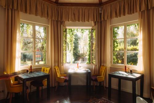 a dining room with two tables and windows at Cortisen am See - Adults only in St. Wolfgang