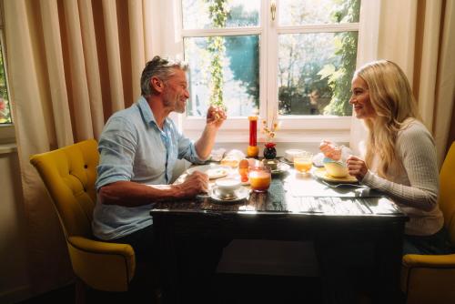 a man and a woman sitting at a table at Cortisen am See - Adults only in St. Wolfgang