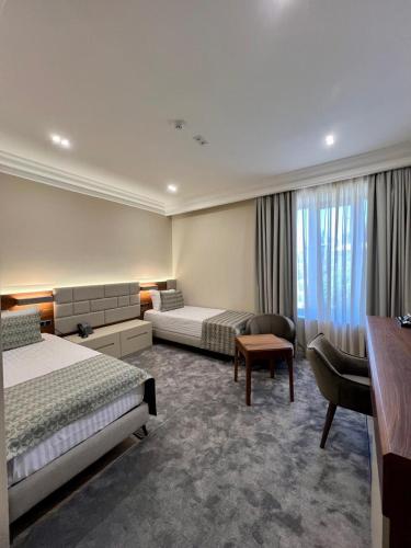a hotel room with a bed and a couch at Plaza Viktoria Hotel Yerevan in Yerevan