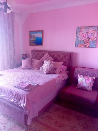 a pink bedroom with a bed and a chair at Guest House Cinderella in Herceg-Novi