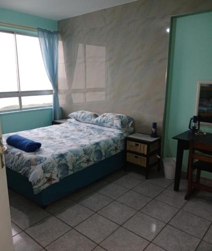 a bedroom with a bed and a desk and a window at Afsaal Sea view apartments in Amanzimtoti