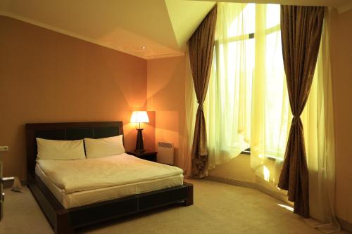 a bedroom with a bed and a large window at Dilijan Park Resort & Villas in Dilijan