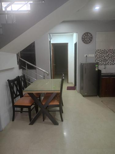 a table with two chairs and a refrigerator in a room at Villa A1 in Pali