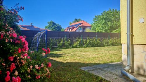 a garden with flowers and a fence at Kristóf apartman in Gyenesdiás