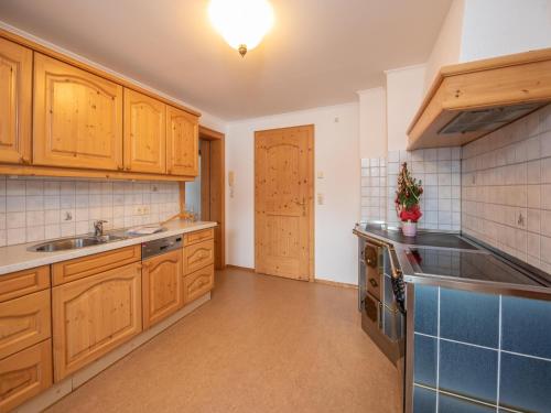a large kitchen with wooden cabinets and a sink at Apartment in Wald near Krimml Waterfalls in Wald im Pinzgau